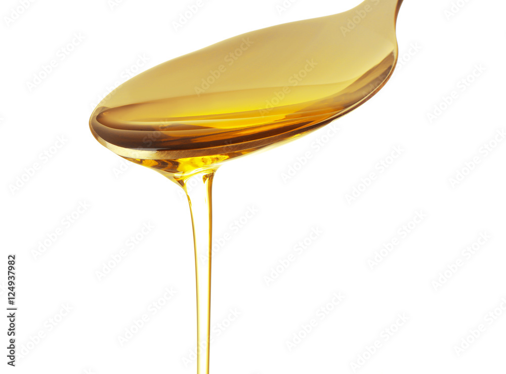 Fish oil dripping from spoon isolated on white, close up view