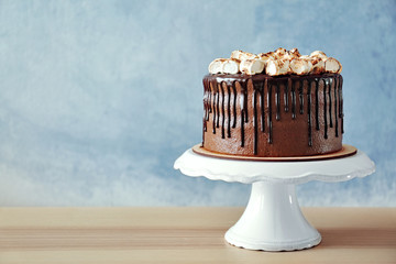 Sticker - Chocolate cake with marshmallow on plastic stand on wall background