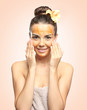 © Africa Studio - Young woman applying scrub on face against color background. Skin care concept.