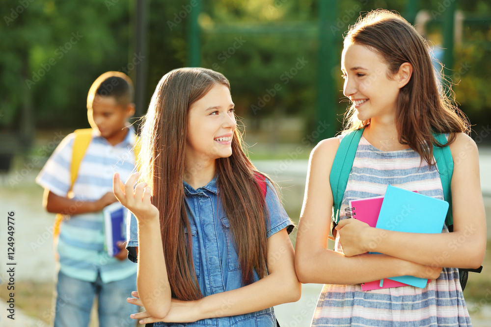 Teenagers with backpacks and notebooks on walking in the park
