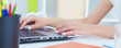 © cameravit - Close up of female hands typing on laptop keyboard.