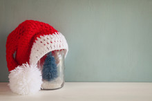 Cute Knitted Santa Hat And Mason Jar With Christmas Tree