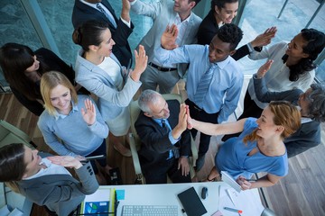 Businesspeople giving high five to each other