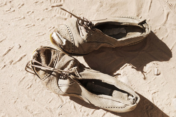 old pair of shoes on sand