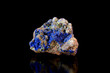 Multicolored rock with lazurite crystals on black background side view