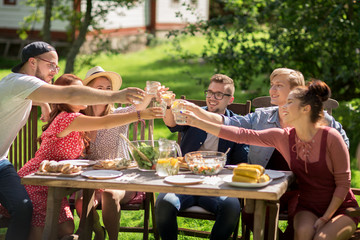 happy friends having dinner at summer garden party