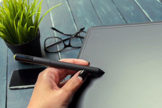 Hand of graphic designer working with stilus and tablet