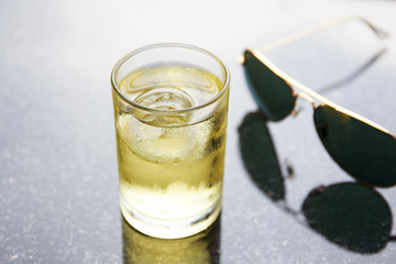 Glass of cold alcohol on table with glasses