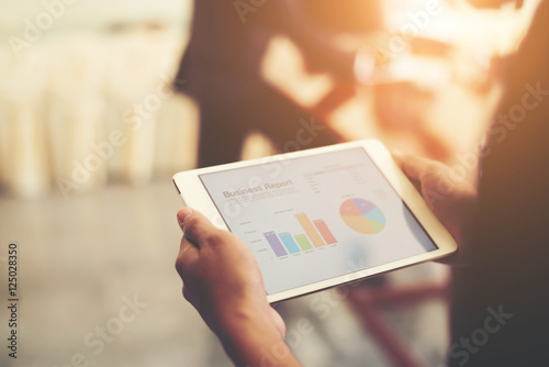 Fotografía Business person hand holding financial statistics displayed on t