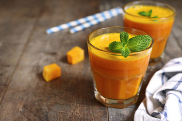 Two portions of fresh pumpkin juice with mint leaf in a glasses.