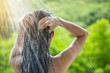 © torwaiphoto - Woman showering and shampooing outdoor