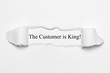 The Customer is King! on white torn paper