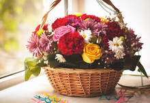 Flowers In The Basket And Happy Birthday Candles, On Wooden Background 