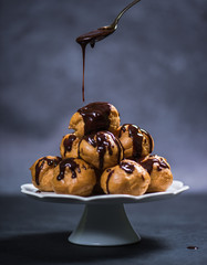 Topping profiterole tower with chocolate