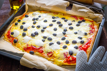 Wall Mural - Homemade Pepperoni Pizza with Black Olives in Baking Sheet