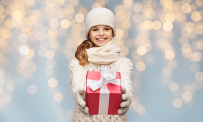 Canvas Print - smiling girl in winter clothes with christmas gift