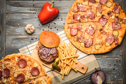 pizza and hamburger on wooden background © qwasder1987