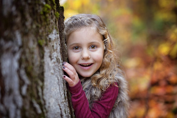 Adorable little girl in a autumn forest