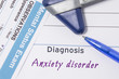 Psychiatric diagnosis Anxiety disorder. On psychiatrist workplace is medical certificate which indicated diagnosis of Anxiety disorder surrounded of questionnaire mental status exam and reflex hammer