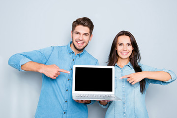 Sticker - Happy man and woman showing laptop and pointing on black screen