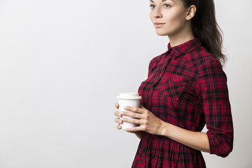 Wall Mural - Side view of thoughtful young woman in red dress with coffee cup