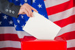 Hand with ballot and box on Flag of USA