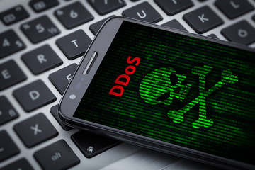 ddos attack I skull of death symbol on mobile phone screen