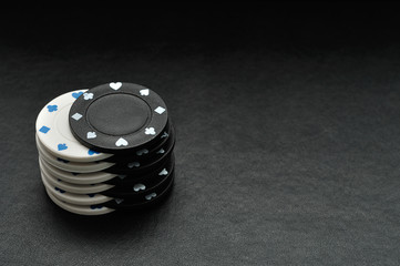 White and black poker chips on a black background