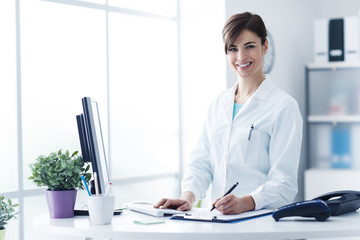 Wall Mural - Smiling female doctor working at the clinic