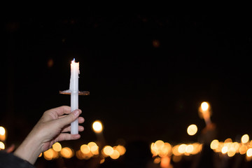 Wall Mural - Blurred image for background of hand with candle memorable for King Bhumibol Adulyadej of thailand