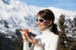 © plprod - femme souriante à la neige sur un balcon avec de la crème solaire