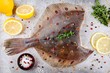 Raw flounder fish, flatfish on rustic background
