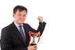 Asian business man in suit holding golden trophy