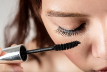 Woman Applying Black Mascara On Eyelashes With Makeup Brush