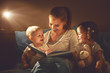 © JenkoAtaman - happy family mother and children read a book in bed