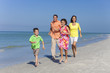 © Darren Baker - Mother, Father and Children Family Running Having Fun At Beach