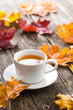 Cup of tea with autumn leaves.