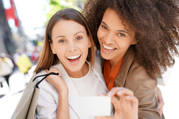 Wall Mural - Girls on a shopping day showing card to camera