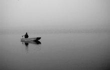Fisherman On A Boat In Fog