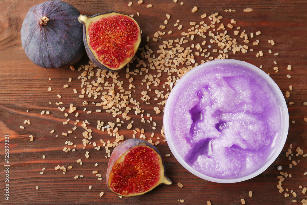 Body scrub and figs on wooden background