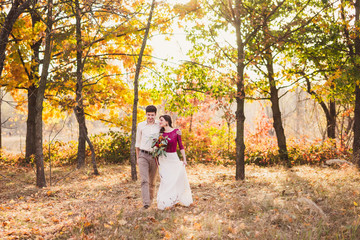 Stylish and romantic caucasian couple in beautiful autumn park. Love, relationships, romance, happiness concept. Bouquet in girl's hands.