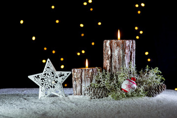 Christmas decorations and candles on snow at night