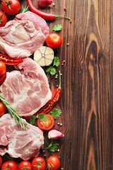 Canvas Print - Raw meat, tomatoes and spices on wooden background