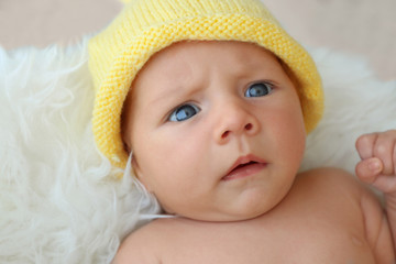 Poster - Cute baby lying on white fluffy plaid, close up view