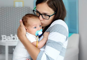 Poster - Portrait of young woman and baby with dummy, close up view