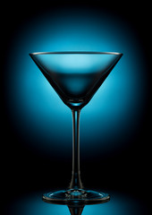 Empty martini glass on a color background.