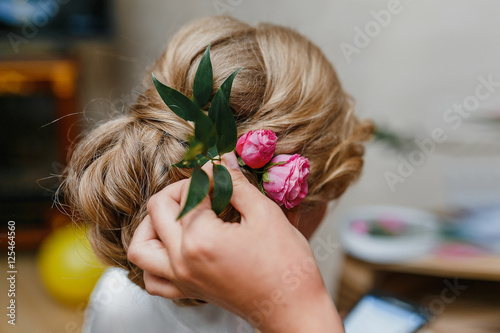 Juliste Hair stylist makes bride a wedding hairstyle with fresh flowers