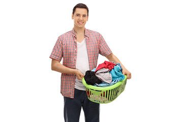 Canvas Print - Young man holding a laundry basket full of clothes