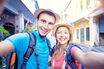 Wall Mural - Tourism and technology. Traveling backpacker couple taking selfie together outdoors.