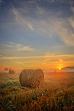 Sunset Over Field With Hay Bales